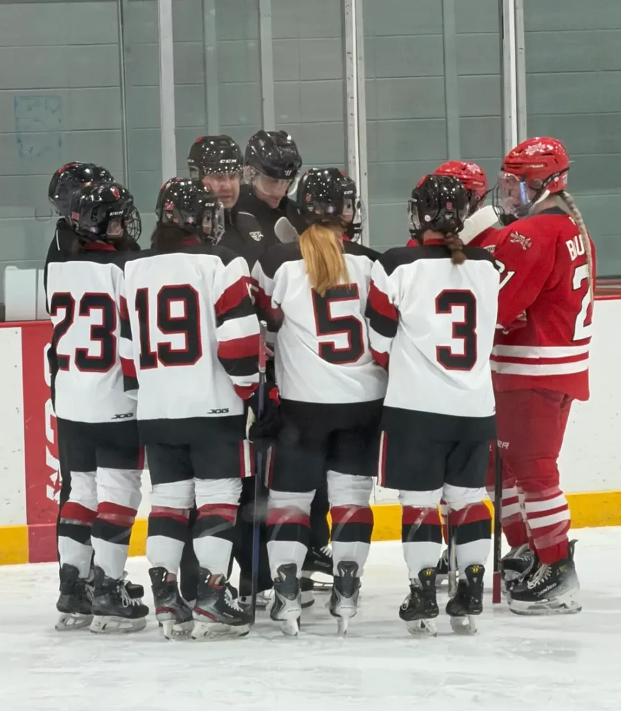 From the Rink to the Boardroom hockey players in an huddle and only numbers showing